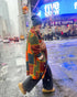 Person walking in a snowy city street with a colorful coat and 8.6.4 cashmere beanie in the color "Norfolk Blue".