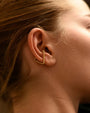 Close up of woman wearing 8.6.4 handmade triangle ear cuff in brass.