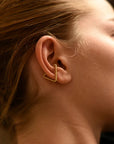 Close up of woman wearing 8.6.4 handmade triangle ear cuff in brass.