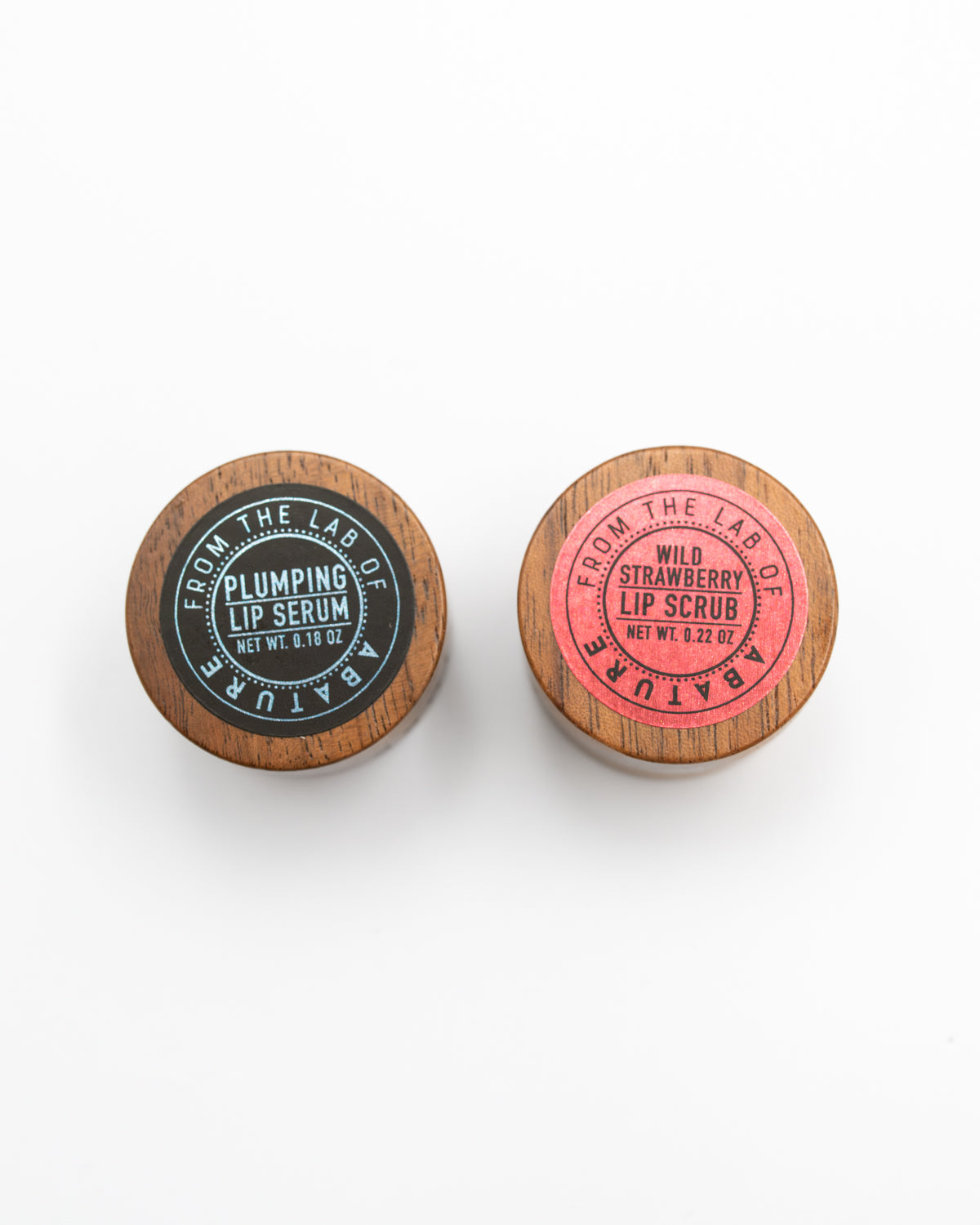 Top view of Abature Plumping Lip Serum and Wild Strawberry Lip Scrub lids