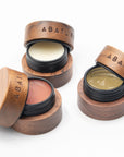 Wooden containers with lip products labeled 'ABATURE' on a white background