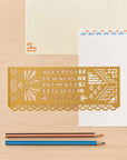 Brass art deco lettering stencil on cream cards with colored pencils