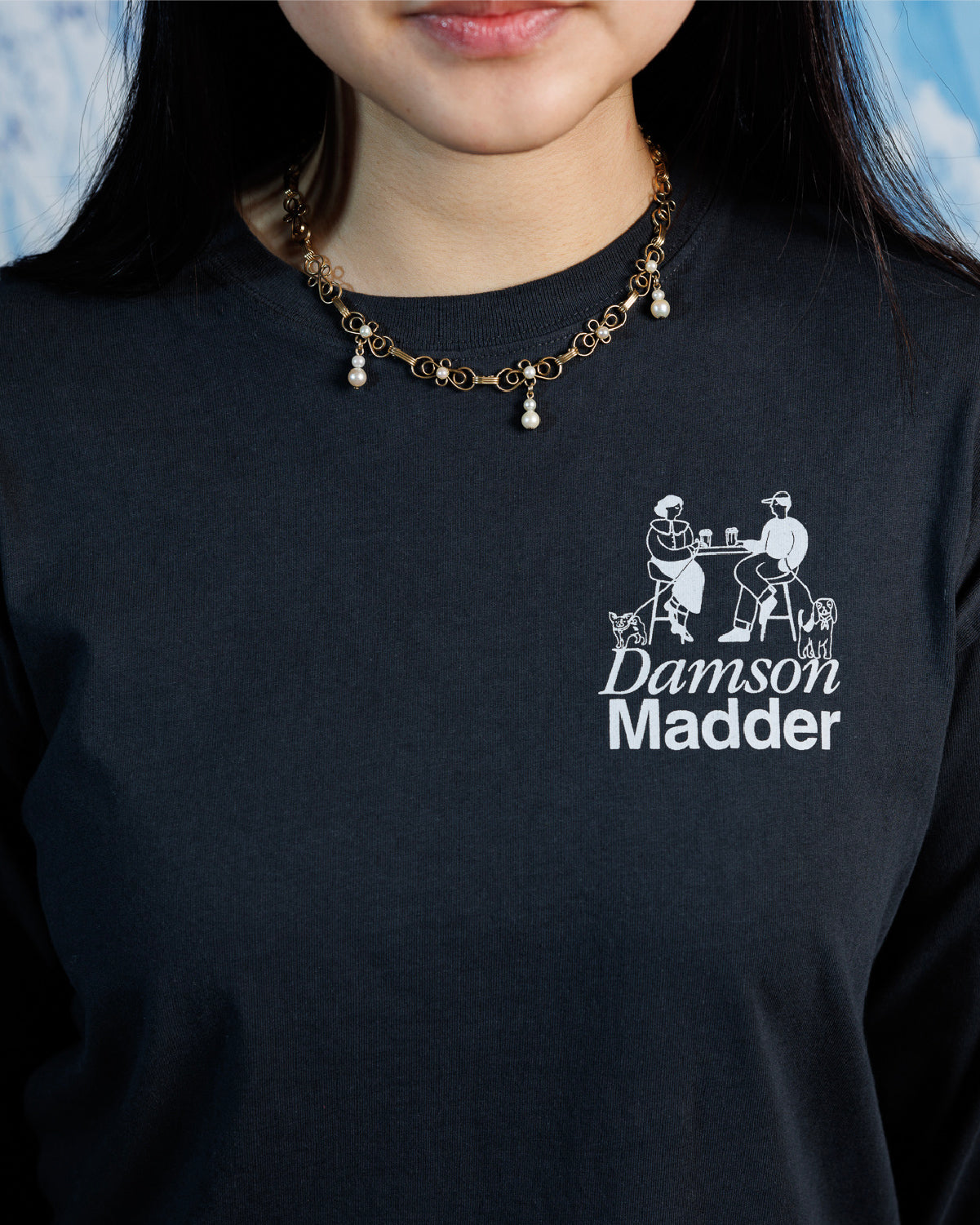 Woman wearing gold-filled 1940s–50s necklace with delicate wire filigree and cultured pearls on a black graphic tee