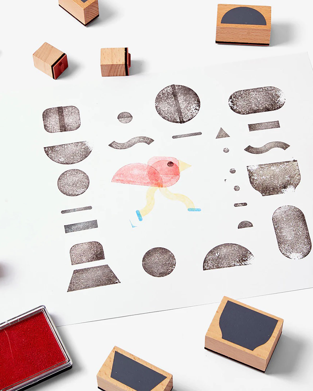 Collection of wooden rubber stamps, stamp pad and children's artwork.