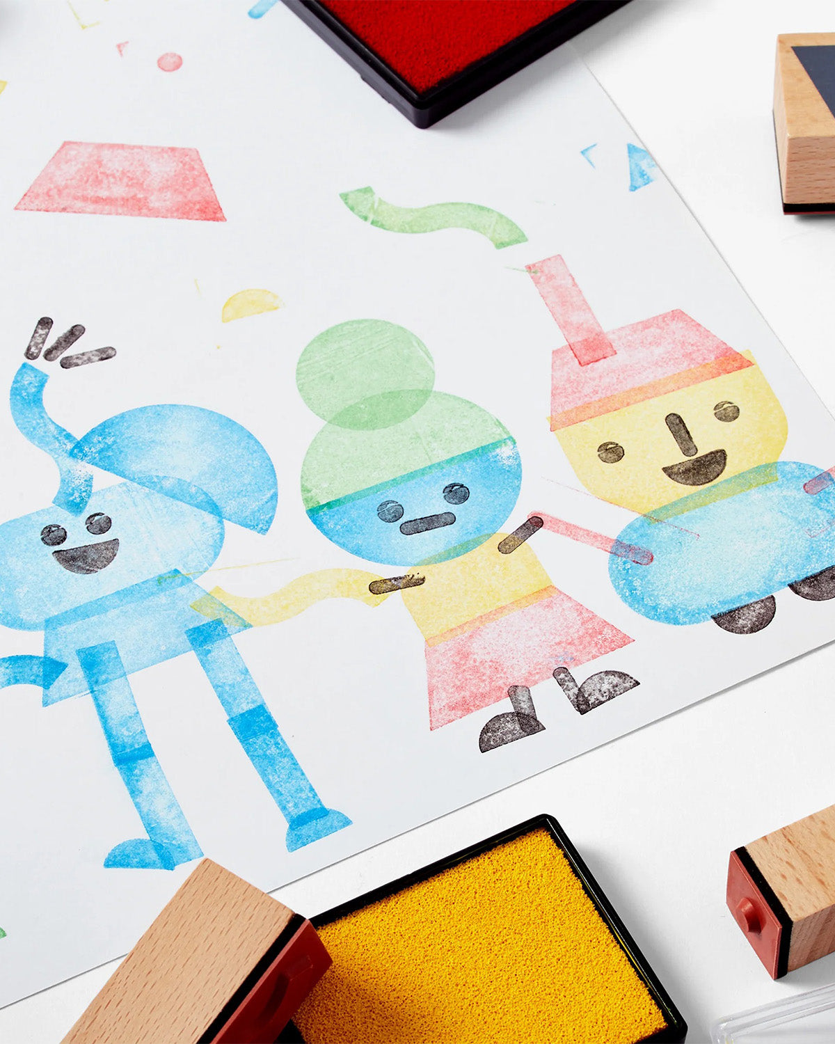 Collection of wooden rubber stamps, stamp pad and children's artwork.