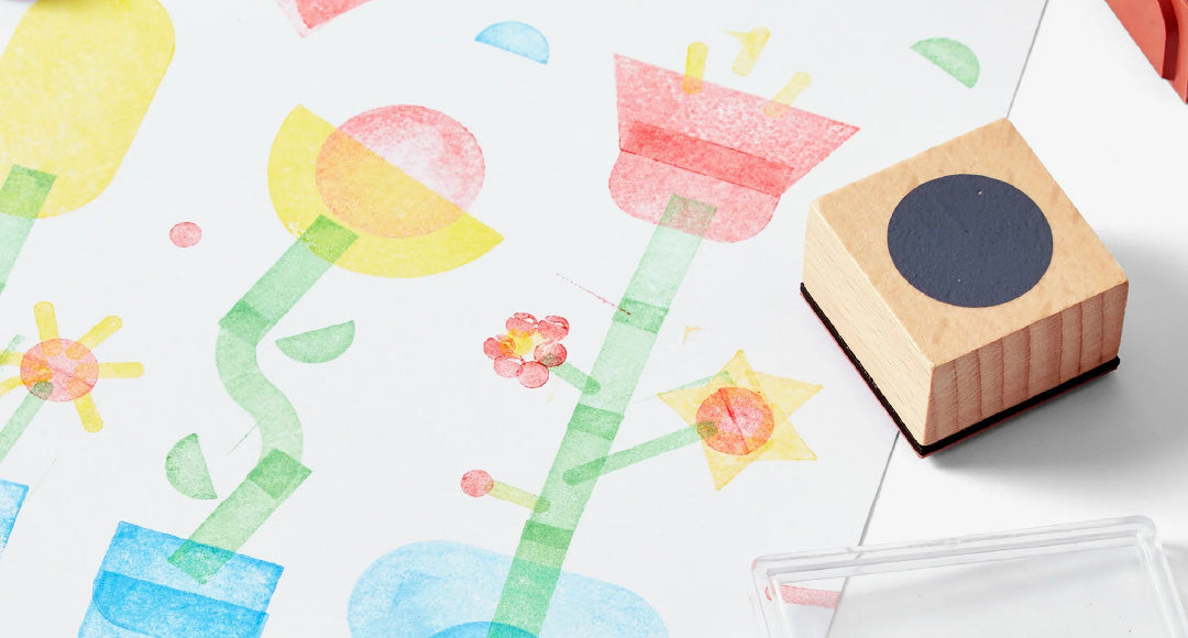 Colorful flower stamps on a white background with a wooden stamp block.