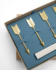 Close-up of gold arrow cheese markers nestled in a blue box with paper banners