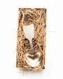 Metal coffee scoop with heart and arrow design in a box of straw on a white background.