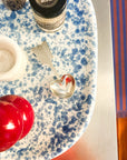 Coffee spoon, handmade with pewter, with heart design on a speckled blue and white surface