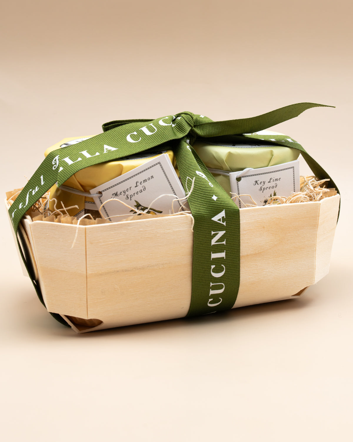 Key Lime and Meyer Lemon spread jars in a wooden basket tied with green Bella Cucina ribbon