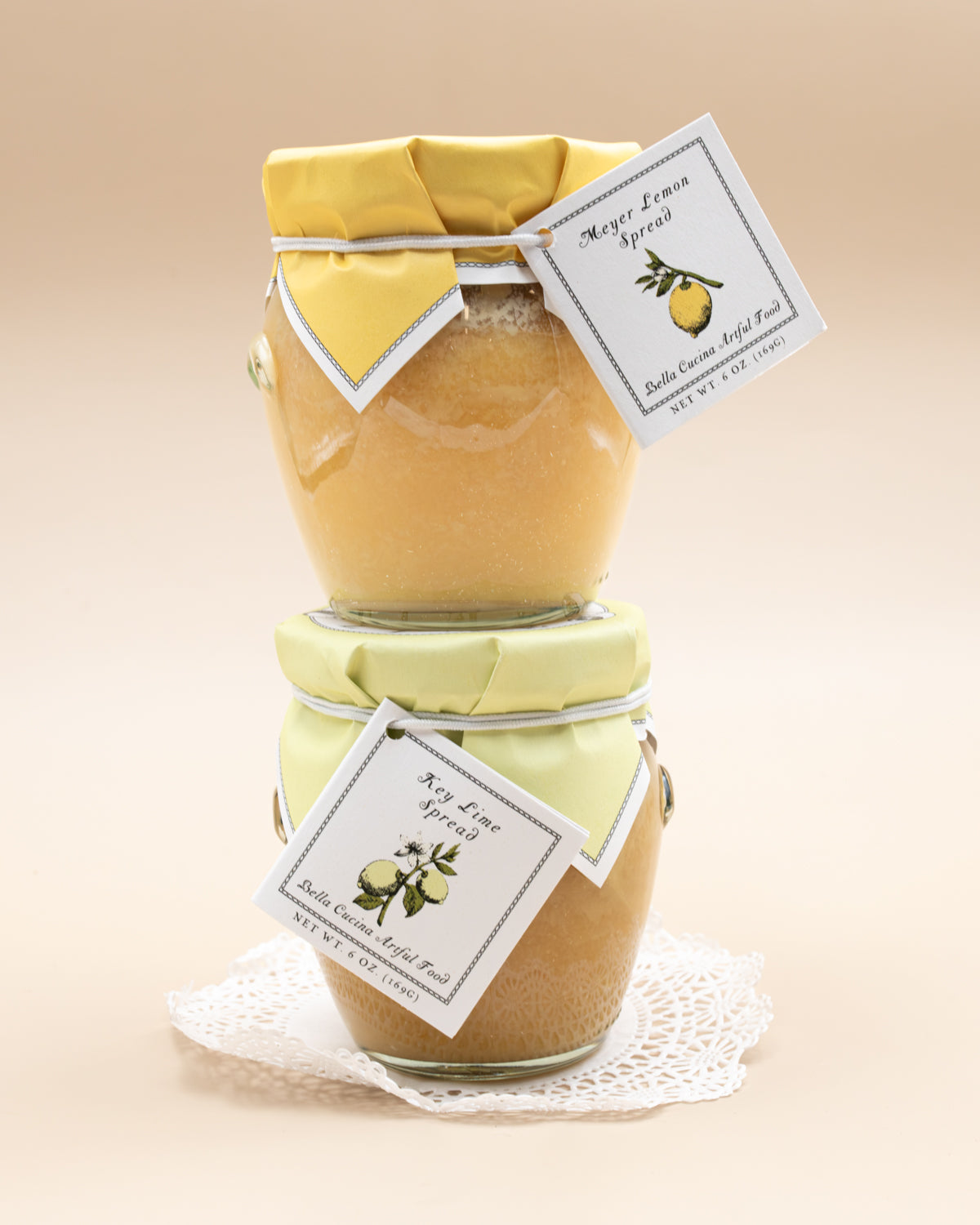 Stacked jars of Bella Cucina Meyer Lemon and Key Lime spreads with fabric lids and tags