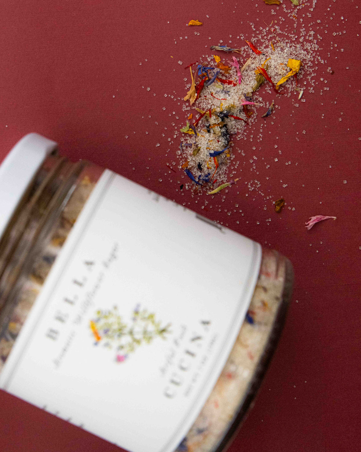 Focus shot of cane sugar mixed with dried blue, yellow and red edible wildflower petals. 