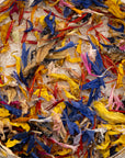Close-up of cane sugar mixed with dried blue, yellow and red edible wildflower petals