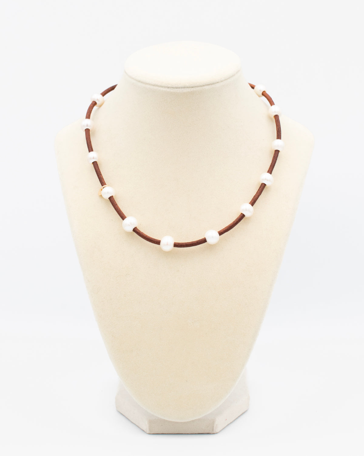 Handmade pearl and leather cord necklace displayed on a jewelry bust