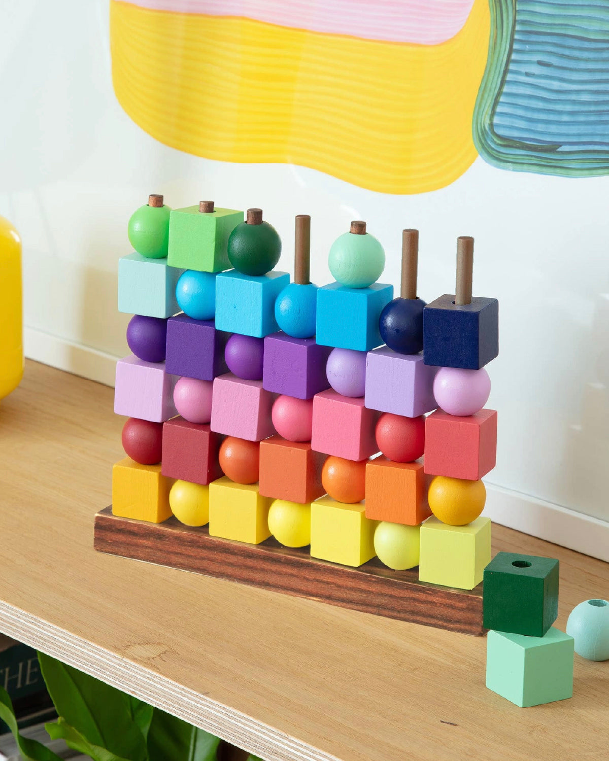 Four in a Row Rainbow wooden game filled with colored cubes and balls on a shelf