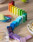 Block Design Gradient Dominoes in rainbow colors lined up in a curve on a table