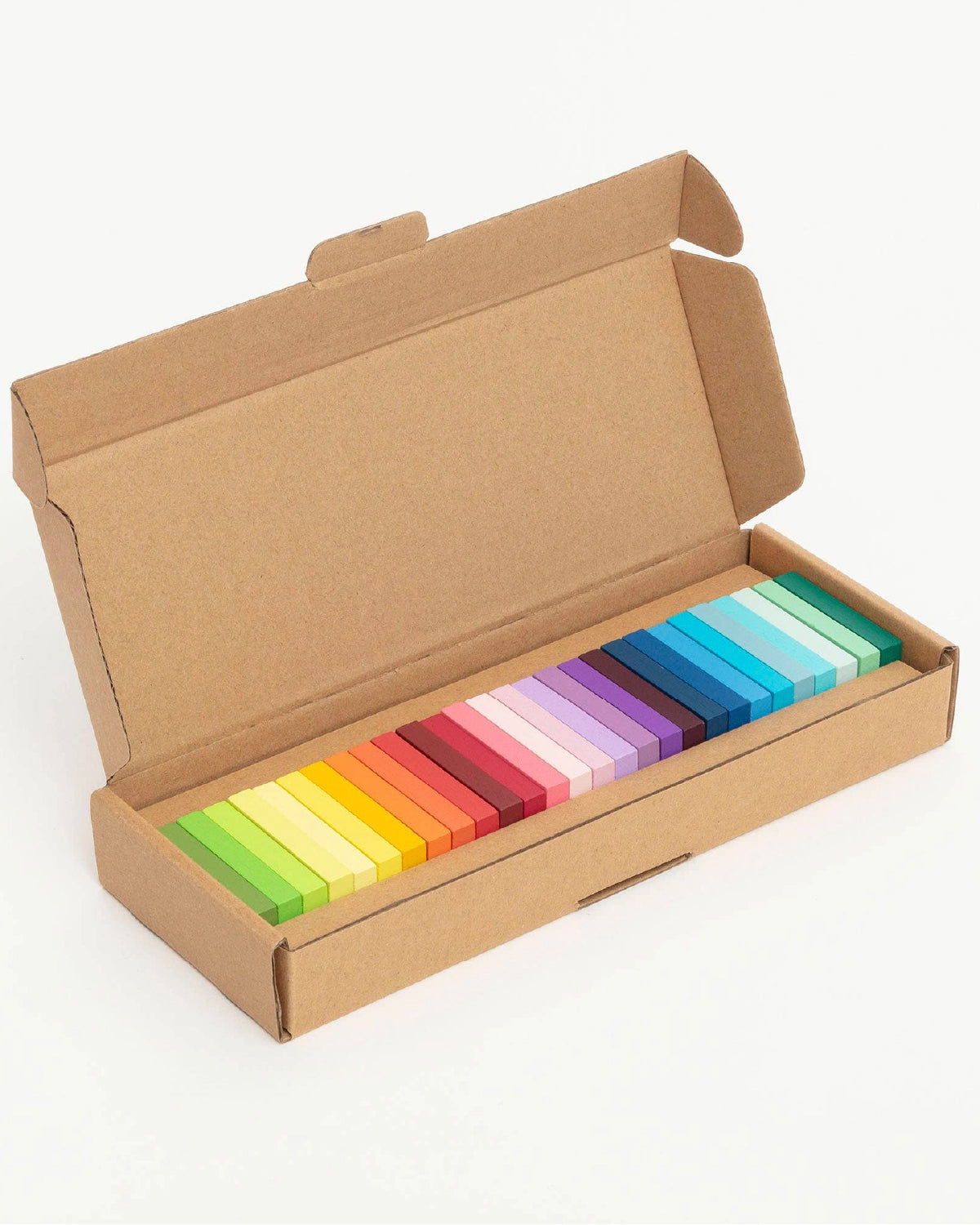 Rainbow gradient dominoes lined up in their open kraft box