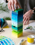 Hand placing a block on top of a Gradient Tower mid-game on a work table