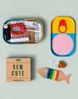Open Sew Cute tin showing mini scissors, thread and needles beside a fish-shaped thread card