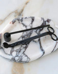 Botanica wick trimmer and bell snuffer in matte black on an oval marble tray