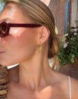 Woman in red sunglasses wearing a green lettuce drop earring
