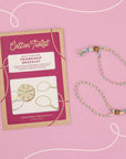 Cotton Twist friendship bracelet kit and finished bracelet on a pink background