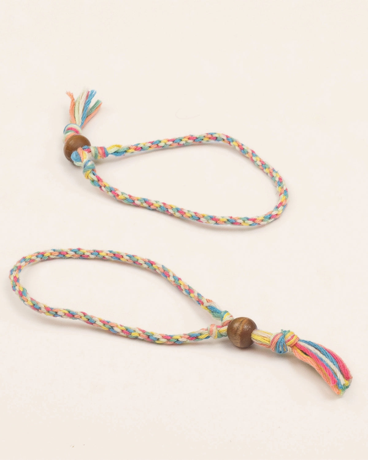 Two finished rainbow braided friendship bracelets with wooden beads