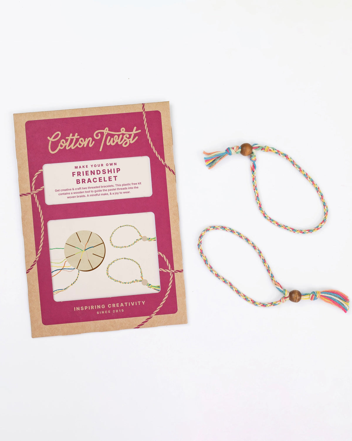 Cotton Twist friendship bracelet kit in pink packaging beside a finished braided bracelet