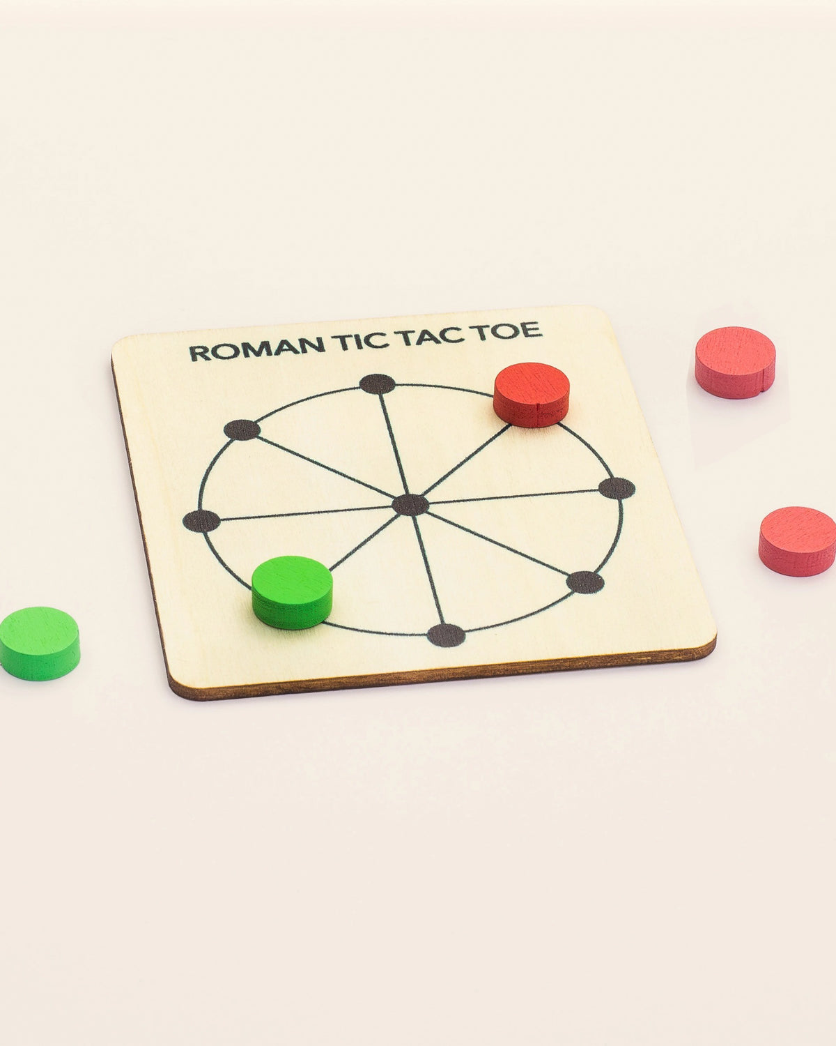 Round wooden Roman Tic Tac Toe board with red and green wooden tokens
