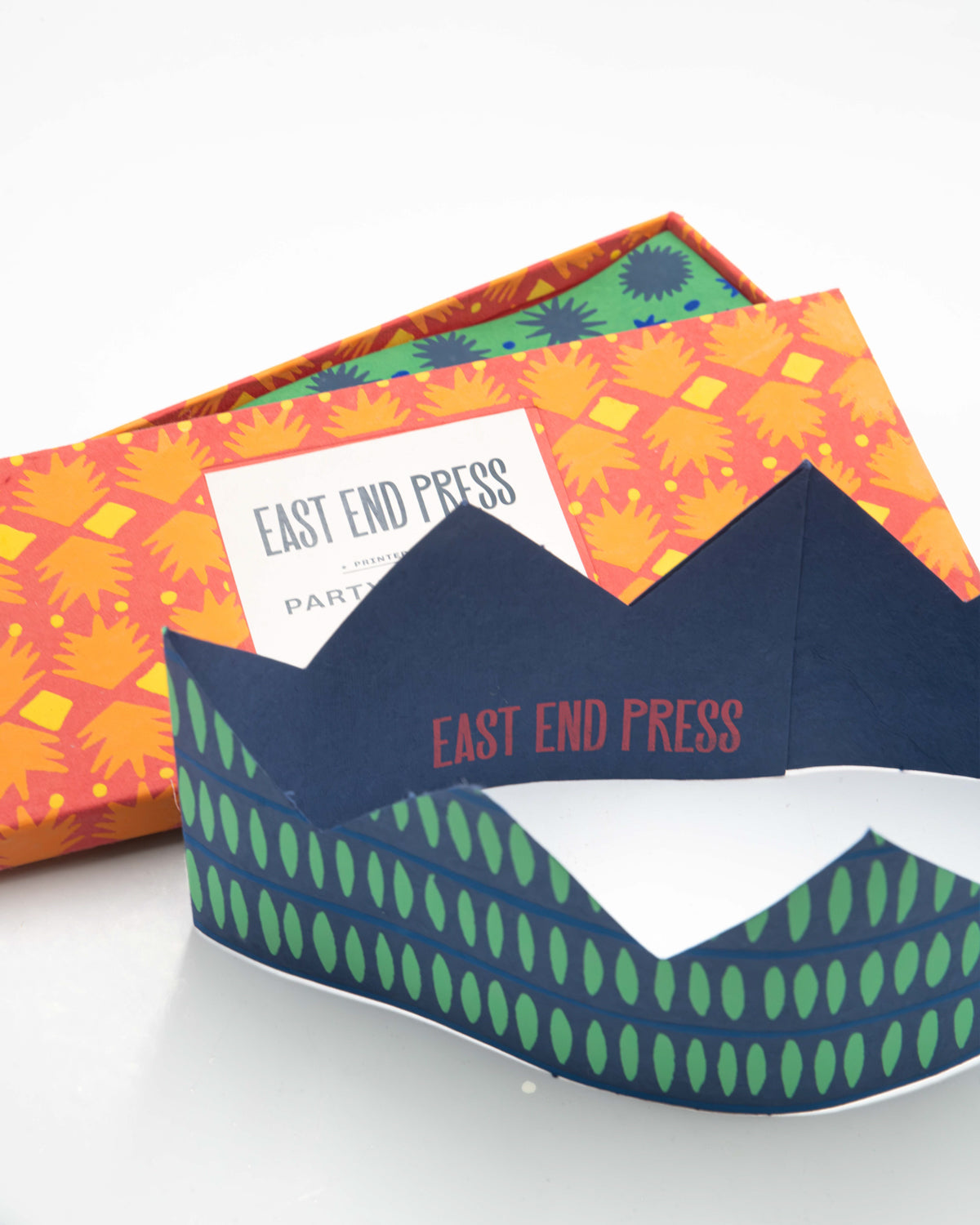 East End Press paper crowns box with a navy and green crown in front