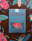 East End Press insect garland in its teal packet, surrounded by paper beetles and moths
