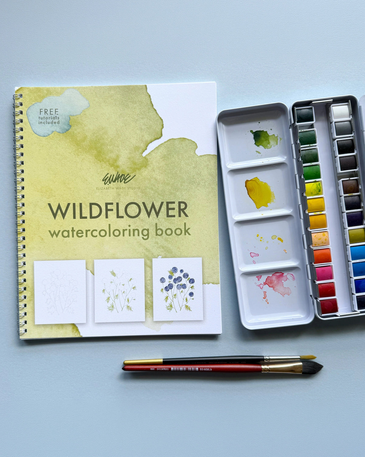 Wildflower watercoloring book with its tin of 24 watercolors and a paintbrush