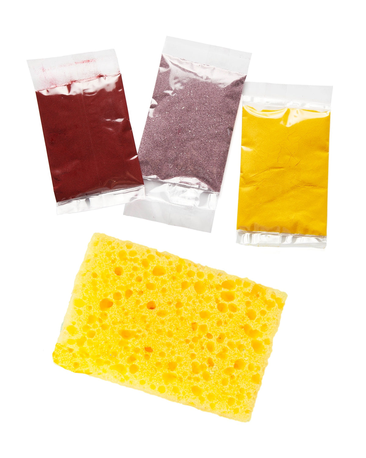 Packets of dried red, purple and yellow herbal inclusions with a yellow sponge from the paper kit