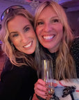 Two smiling women at a party wearing gold glitter freckles on their cheeks