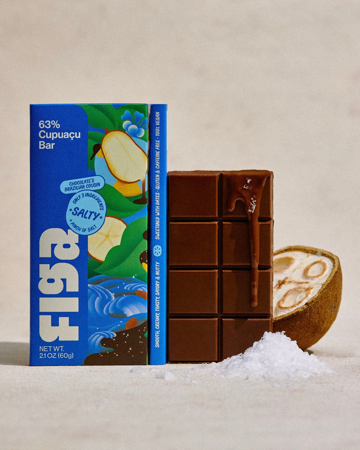 Figa salty 63% cupuacu bar next to an unwrapped bar and a halved cupuacu fruit