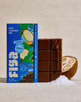 Figa salty 63% cupuacu bar next to an unwrapped bar and a halved cupuacu fruit