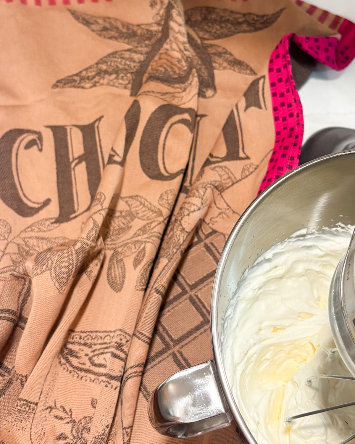 Tasse de Chocolat jacquard towel in cocoa brown beside a mixing bowl of frosting
