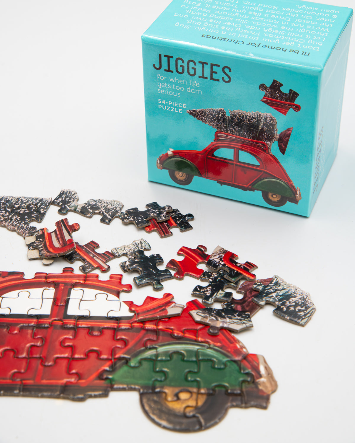 Half-finished red car Jiggies mini puzzle in front of its teal box
