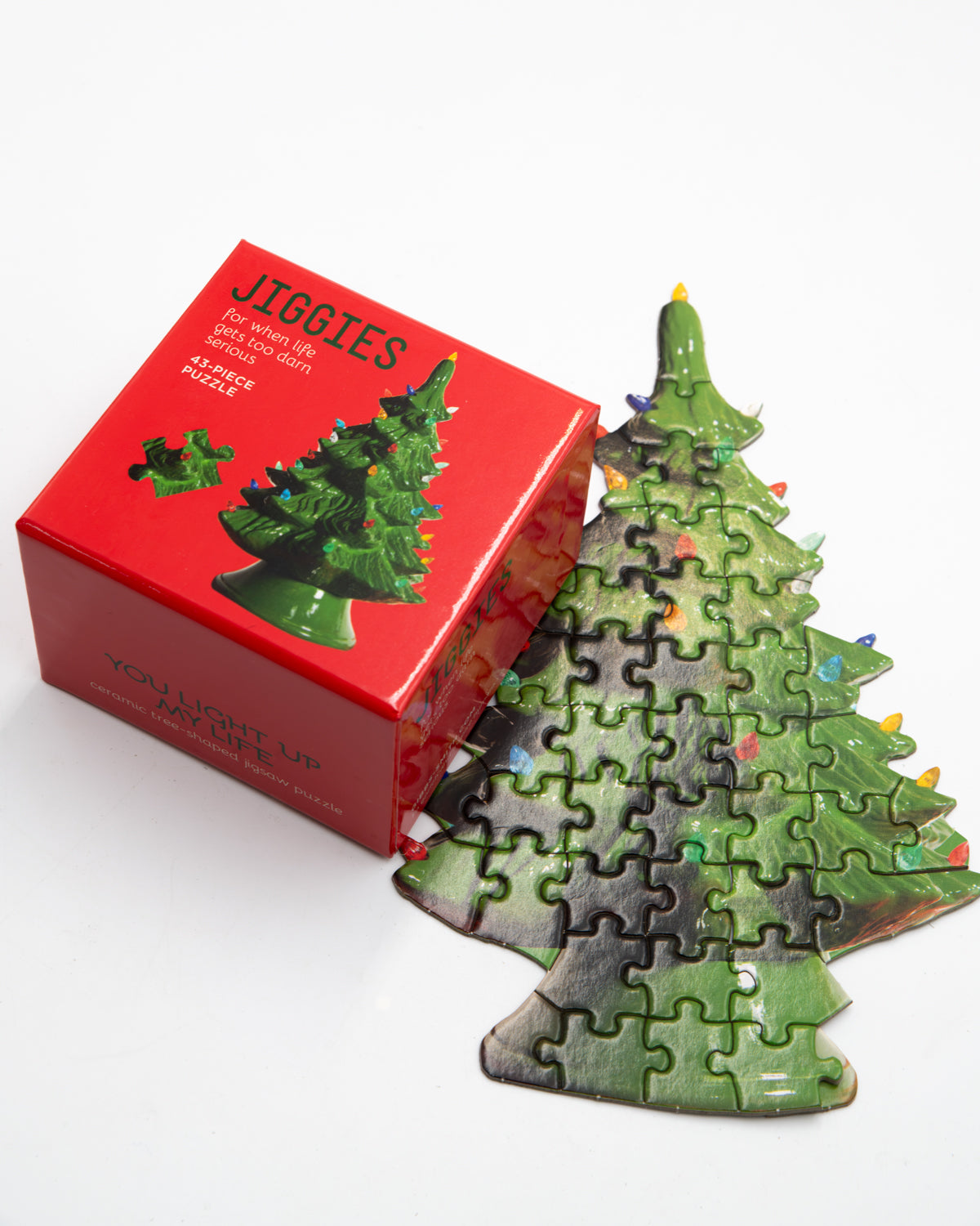 Jiggies mini puzzle shaped like a green ceramic Christmas tree, beside its red box