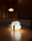 Glowing origami book light on a round table in a dim cabin room