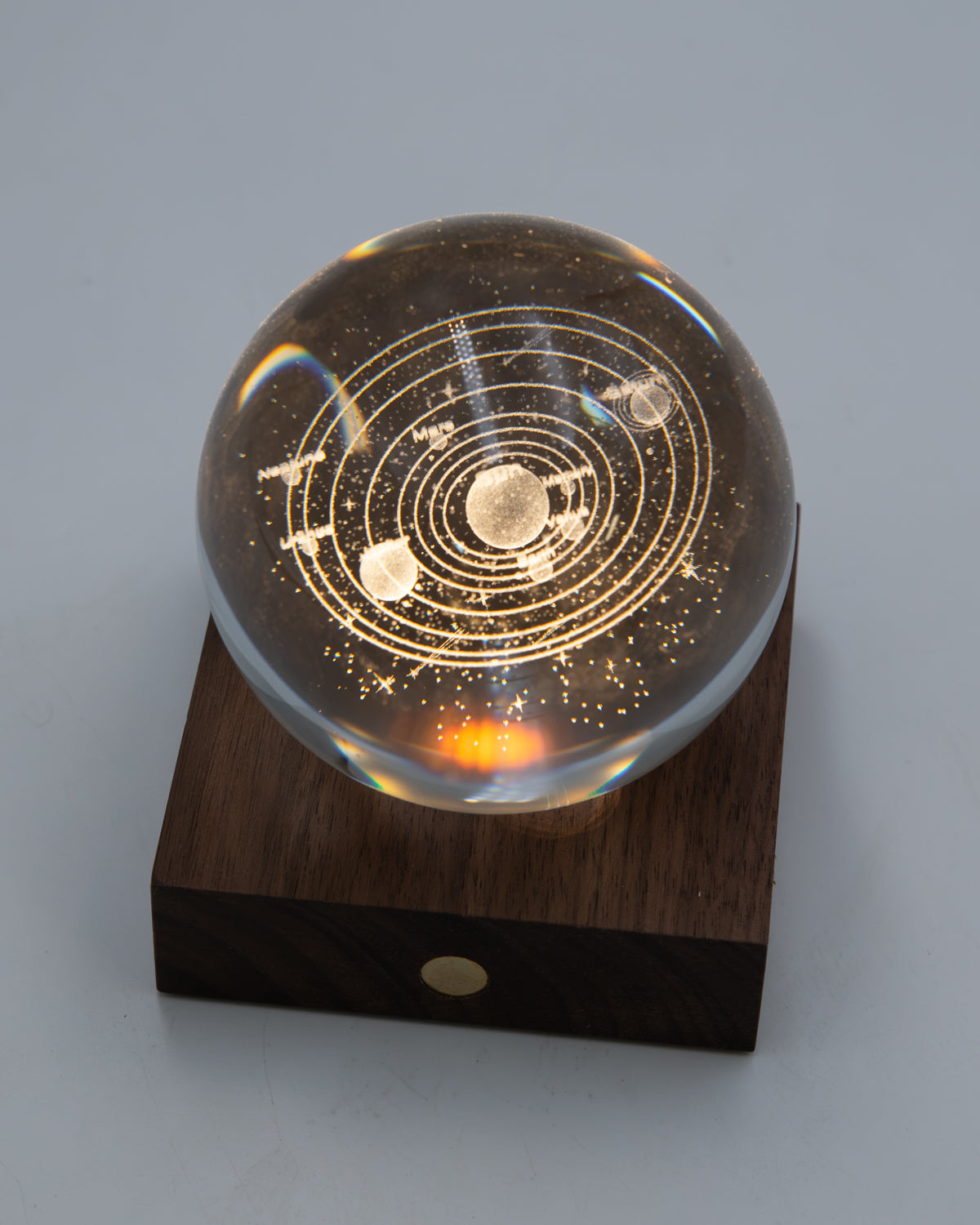 Gingko planetary crystal light glowing amber on its walnut base with a front button