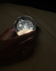 Hand holding the planetary system crystal ball light glowing in a dark room
