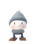Hoptimist Skiing Bumble figure in a blue-gray knit cap with wooden skis