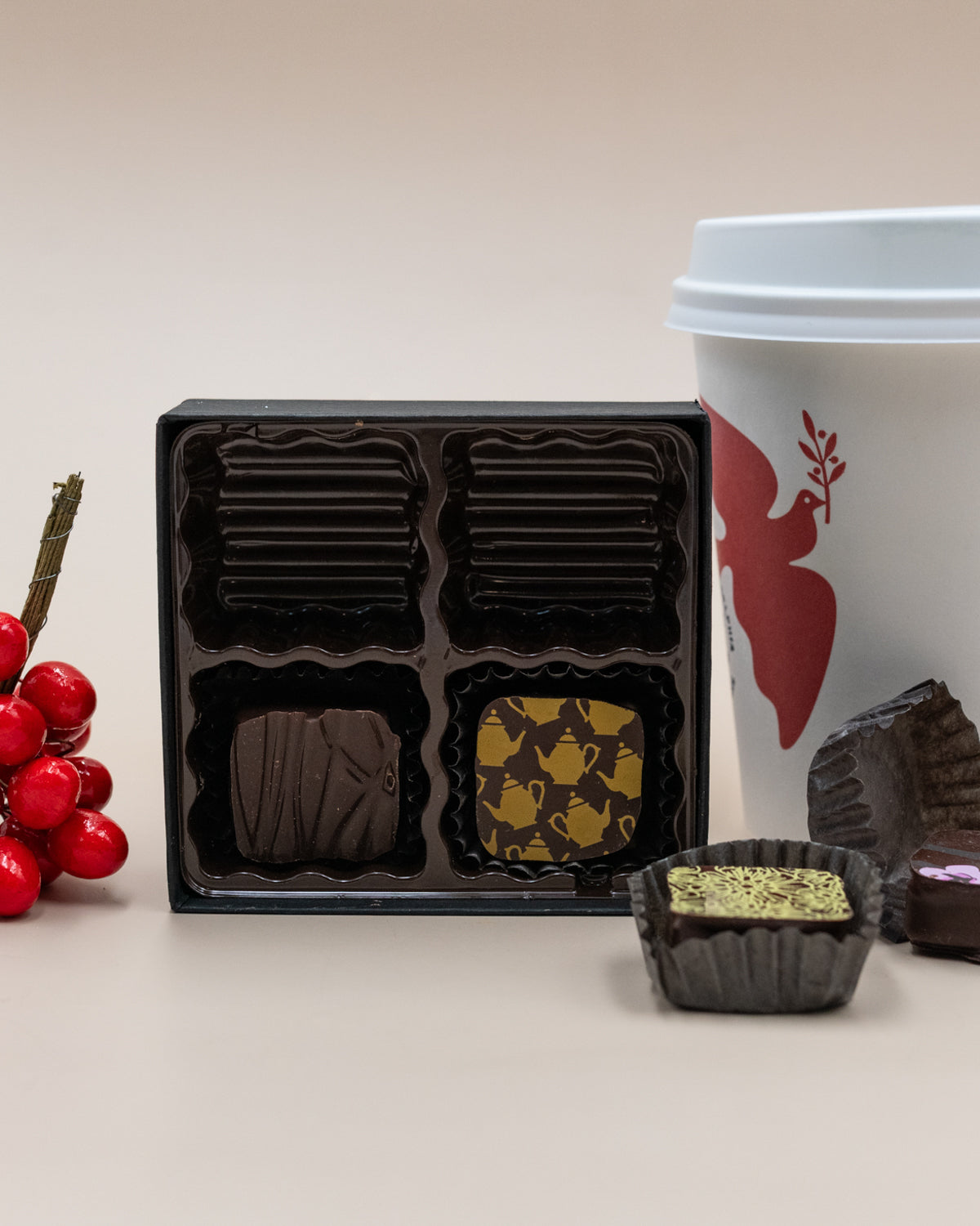MECHA Tea Box ganaches open beside a coffee cup, with one chocolate cut to show its green filling