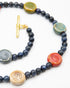 Necklace with blue beads and colorful ceramic discs on a white background