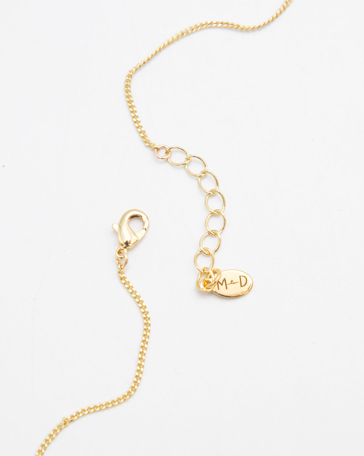Gold necklace with a lobster closure on a white background