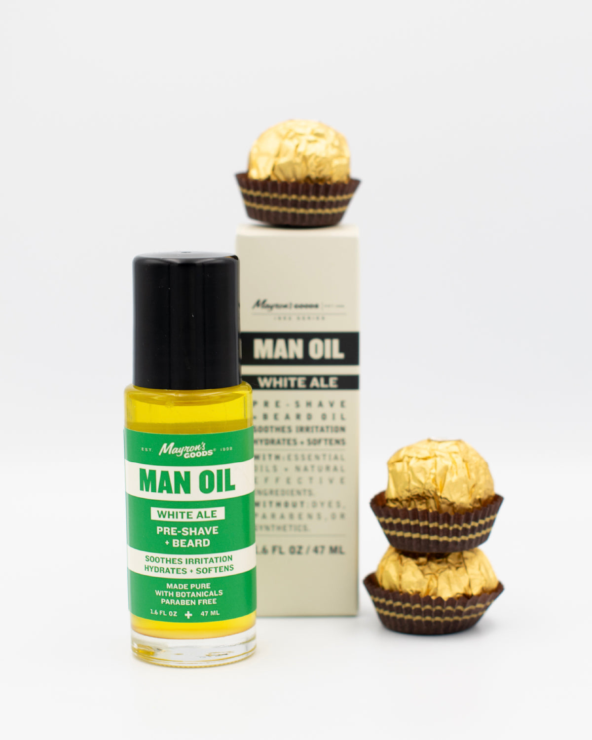 Bottle of Man Oil with Ferrero Rocher chocolates on a white background