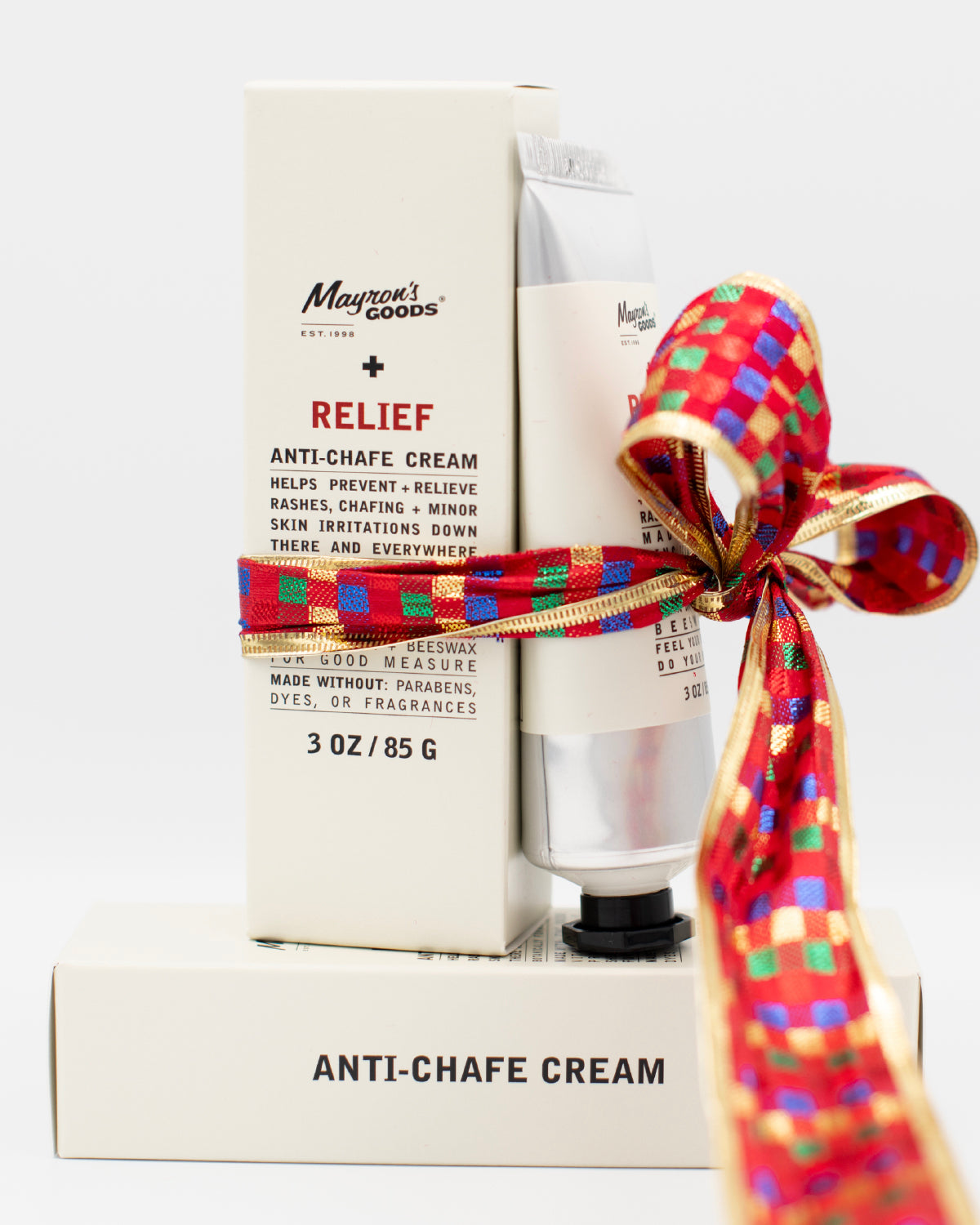 Tube and box of Mayron's Goods Anti-chafe cream with a colorful bow on a white background