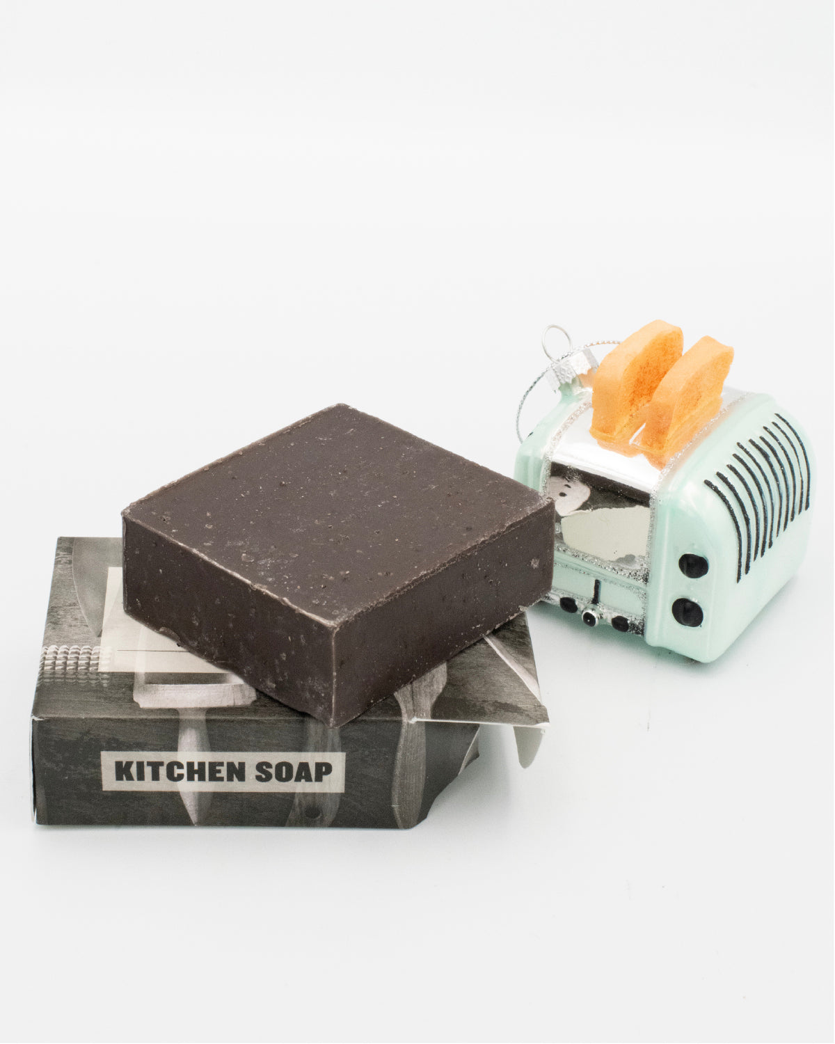 Opened bar of Mayron's Goods Kitchen Soap next to a mini retro toaster holiday ornament