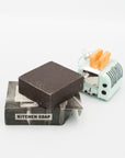 Opened bar of Mayron's Goods Kitchen Soap next to a mini retro toaster holiday ornament